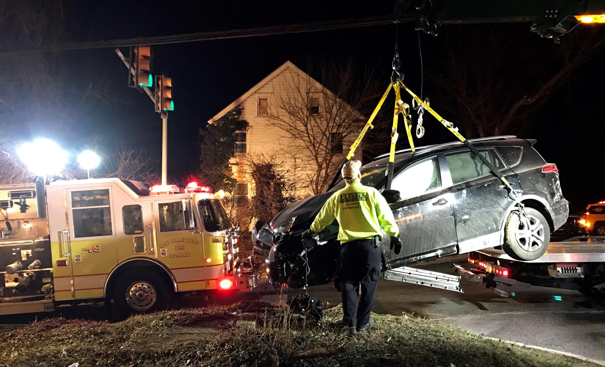 Crane rotator truck lifting a compact car onto a flatbed truck after an accident in Thorndale PA