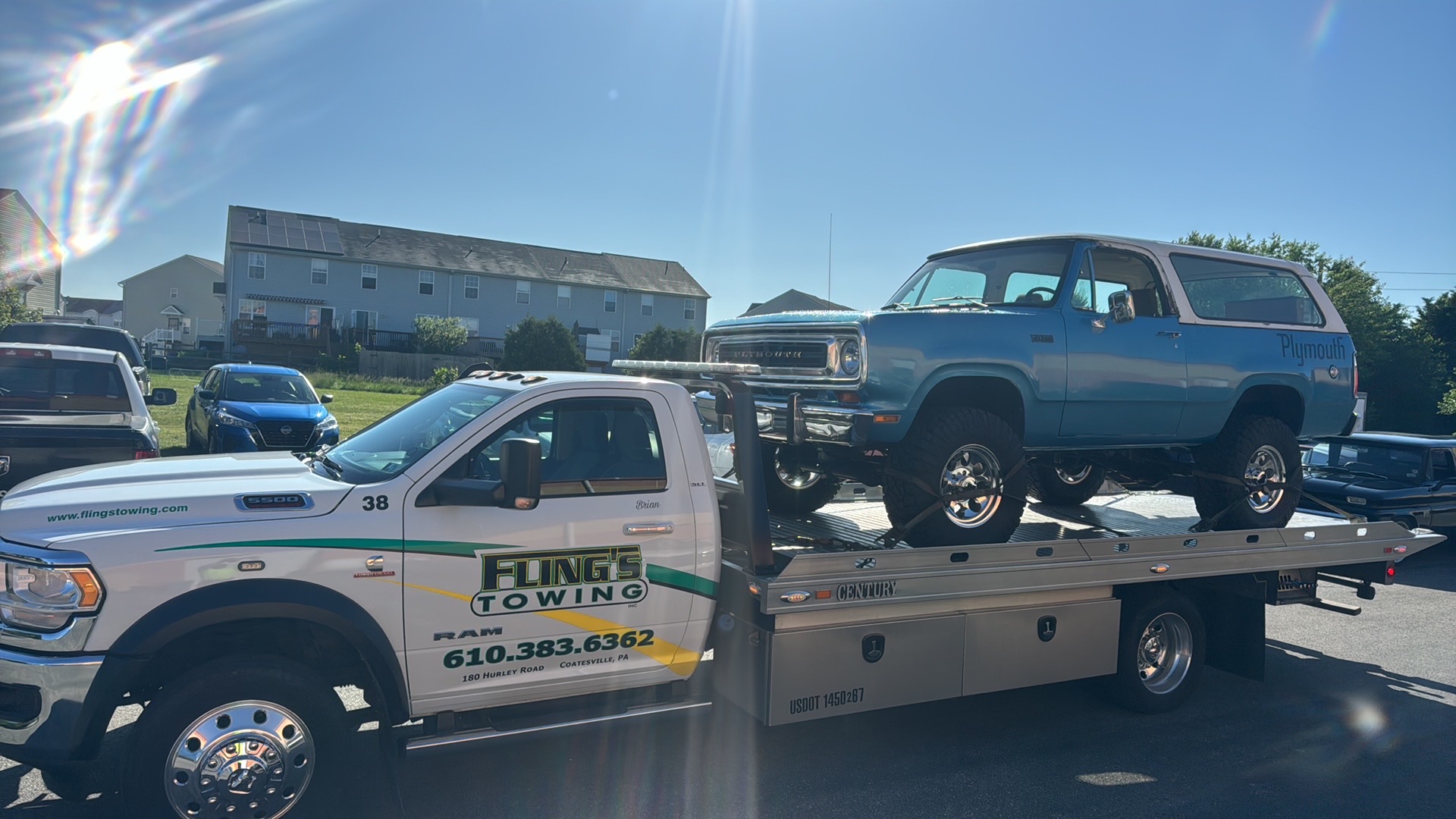 Classic Ford Bronco being strapped and towed on a flatbed truck in Exton PA