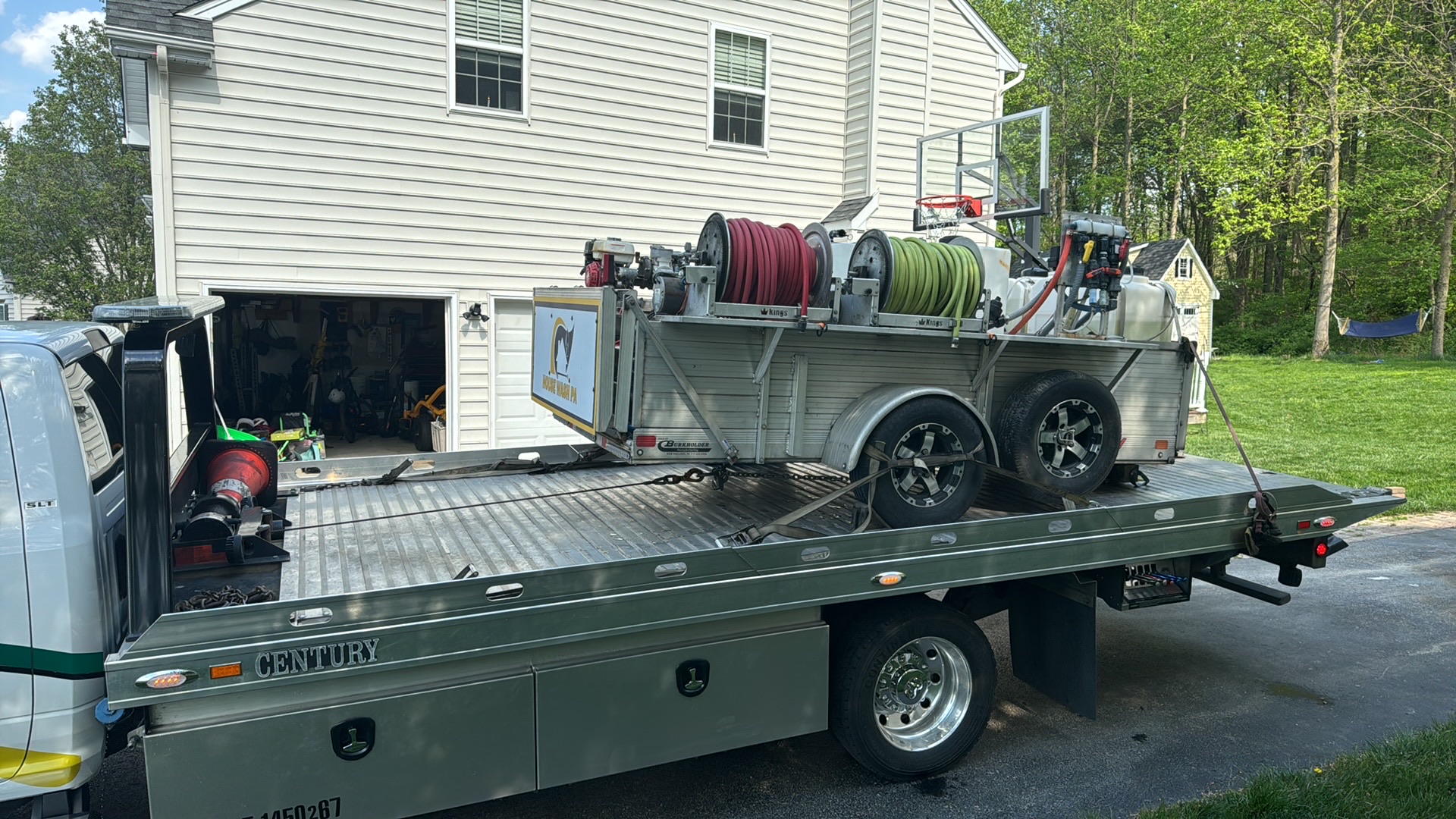 Equipment trailer being towed on a flatbed truck on Parkesburg PA